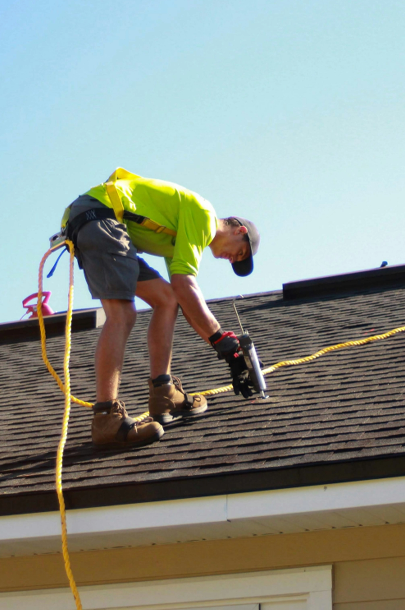 roofer nailing down shingles